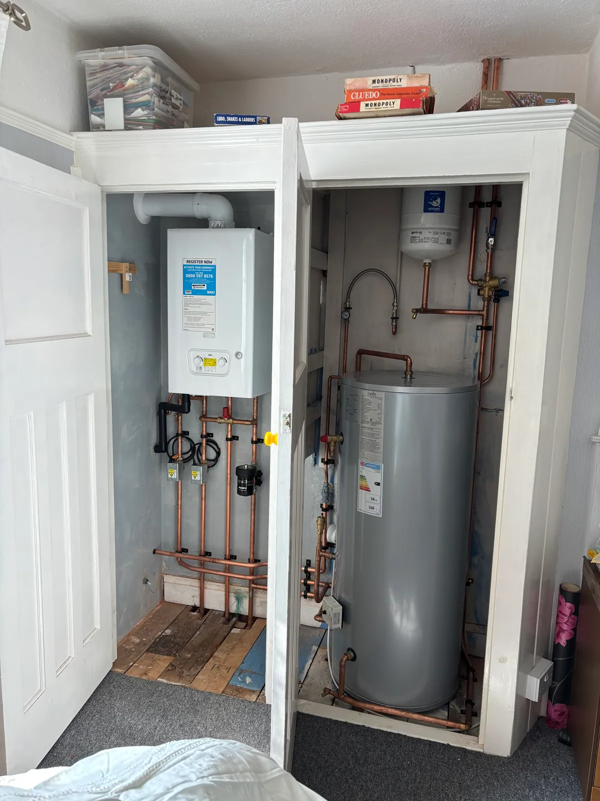 Unvented hot water cylinder and system boiler installed by Howe Heating with copper pipework in an airing cupboard