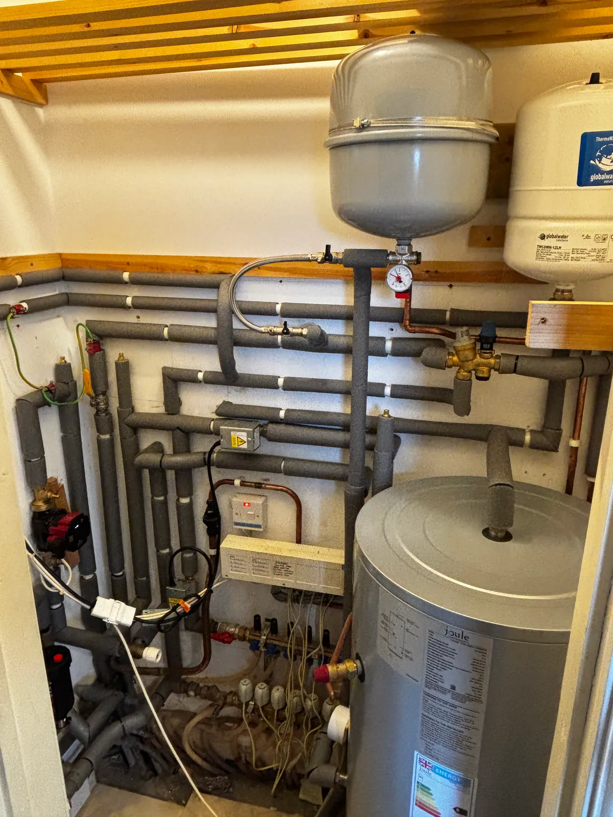 Hot water cylinder, expansion vessels and neatly insulated heating pipework fitted by Howe Heating